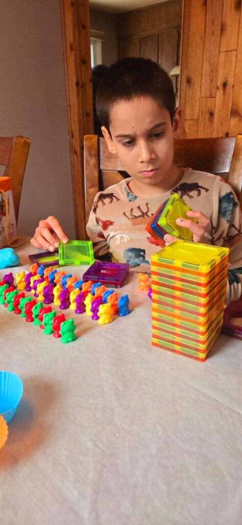 A child sorting colourful counting bears next to a stack of building blocks
